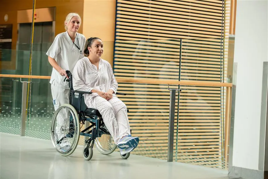 En lege og en pasient i rullestol