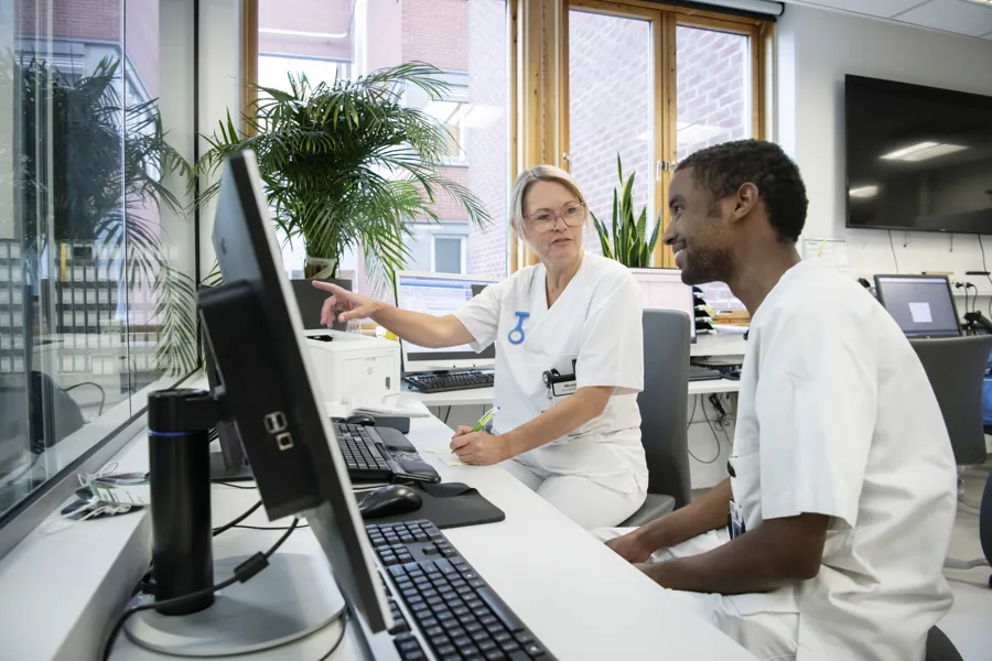 To helsearbeidere foran skjerm