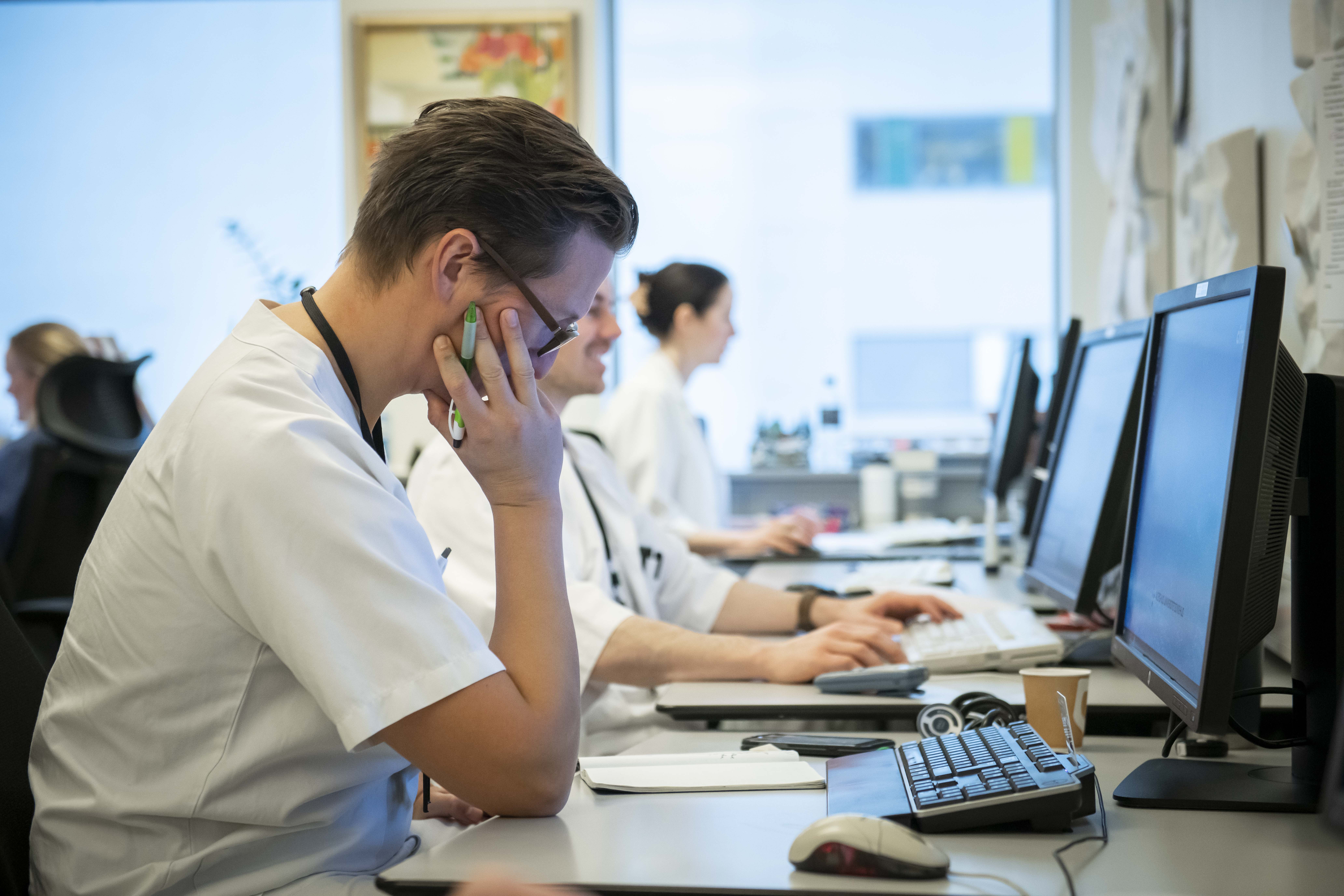 Lege sitter og jobber foran pc