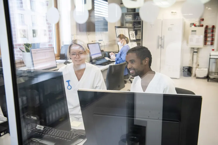 To sykehusansatte sitter foran pc-skjerm