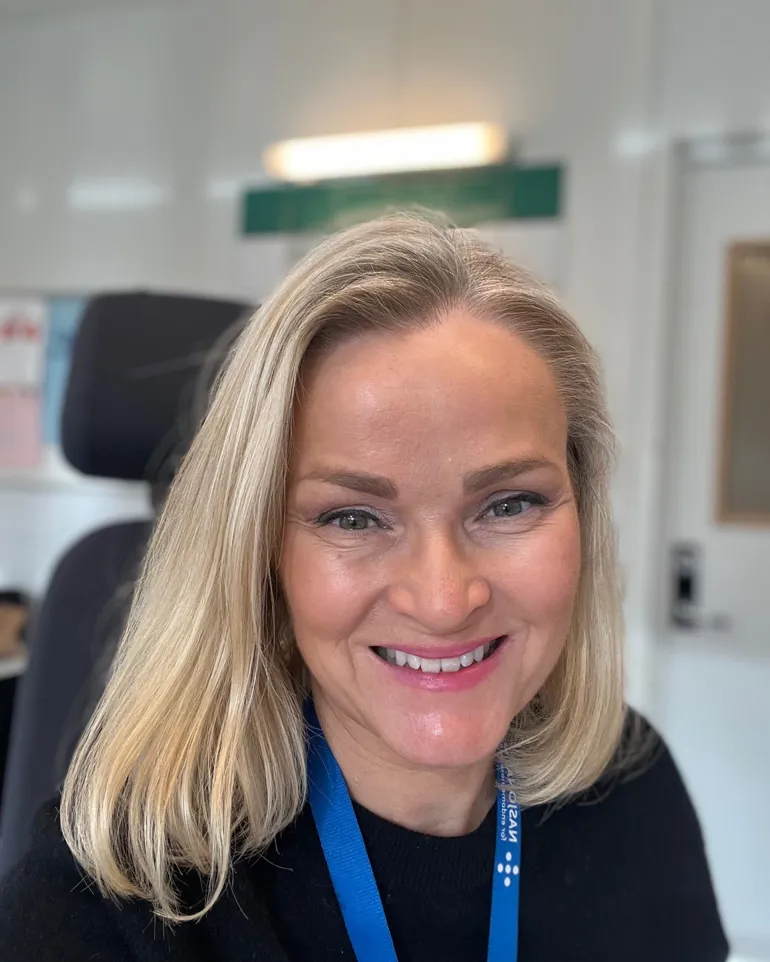 En kvinne som smiler til kameraet