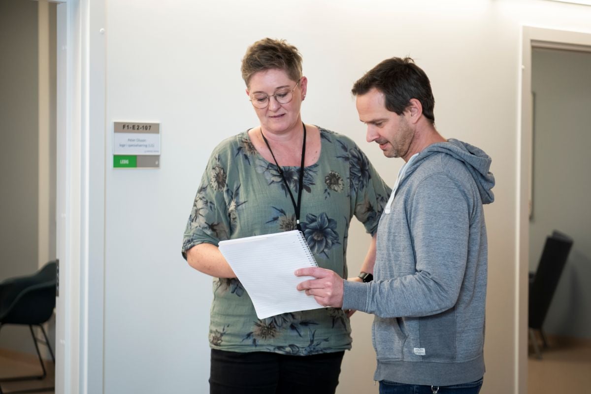 En person som holder et papir og en person som holder et papir