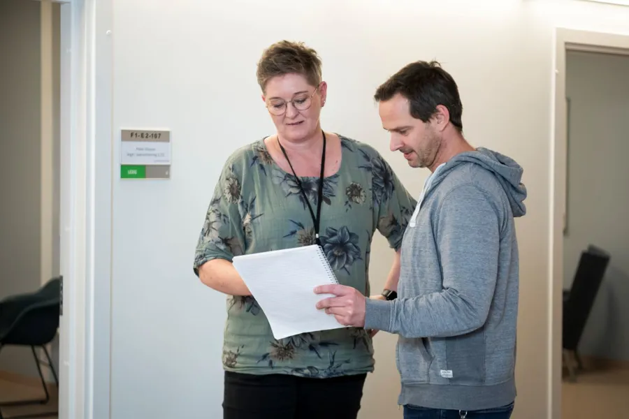 En person som holder et papir og en person som holder et papir