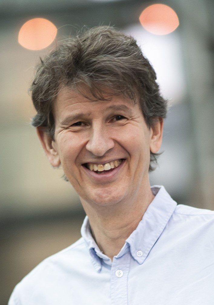 En mann som smiler til kameraet