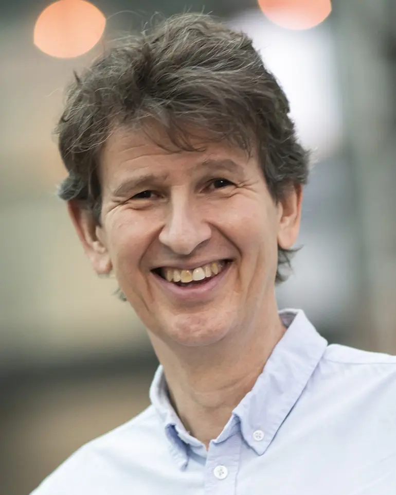 En mann som smiler til kameraet
