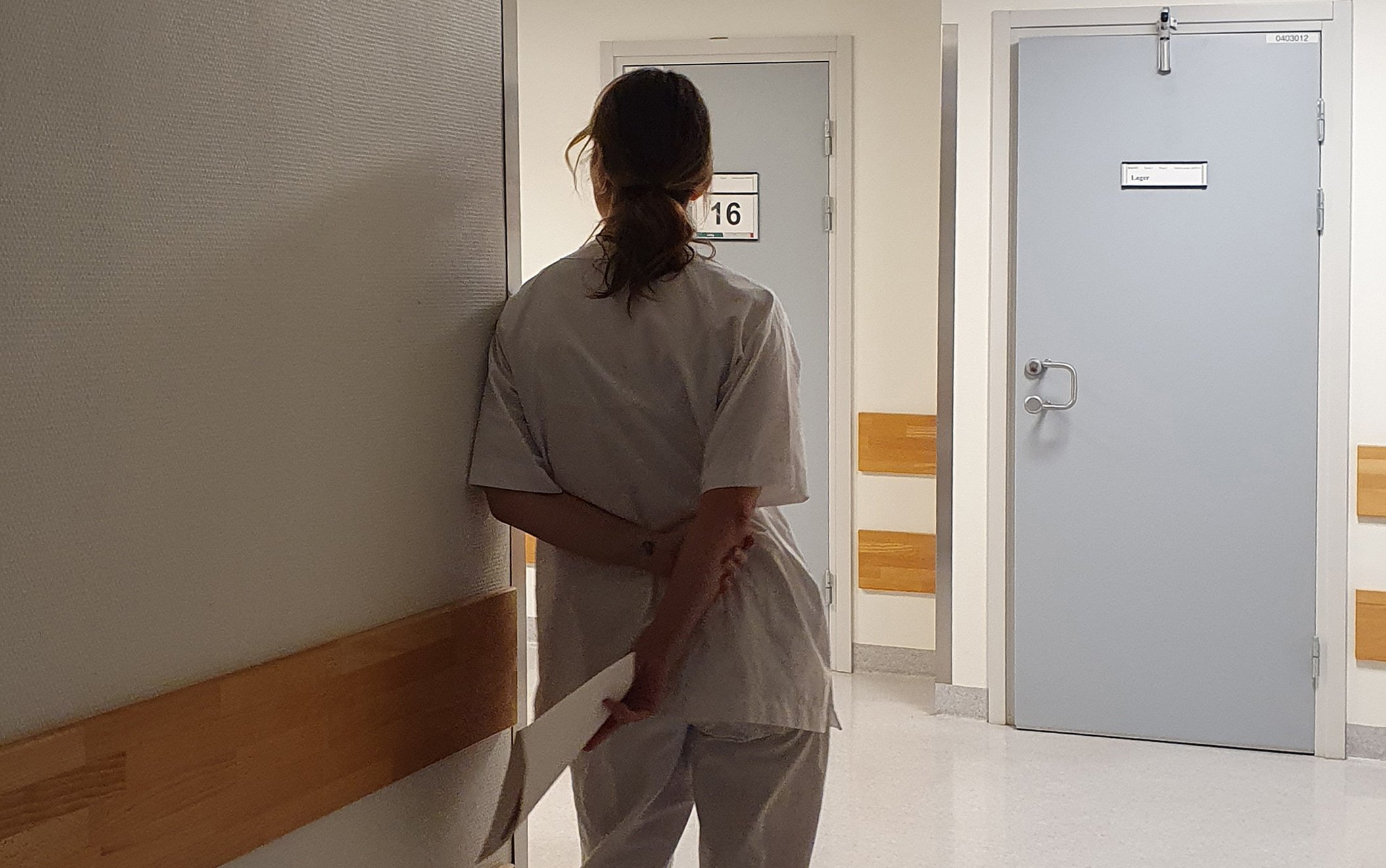 En sykepleier som står i en sykehuskorridor