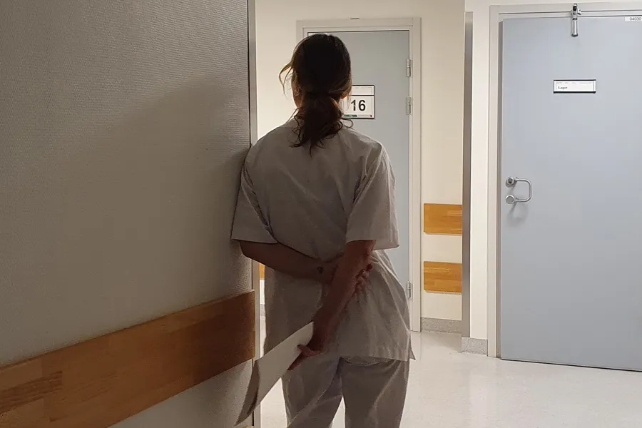 En sykepleier som står i en sykehuskorridor