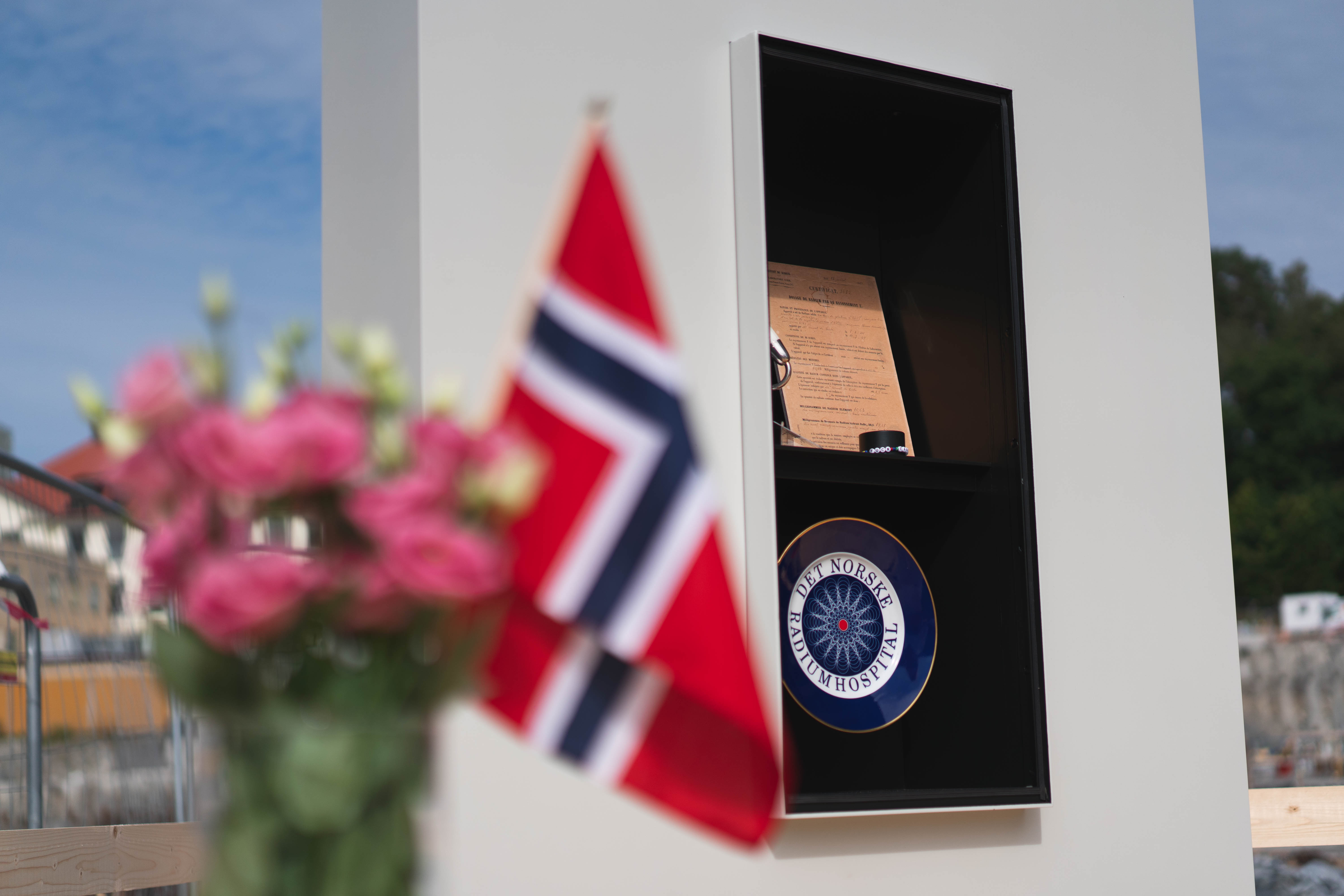 flagg i fokus med grunnstein i bakgrunnen 