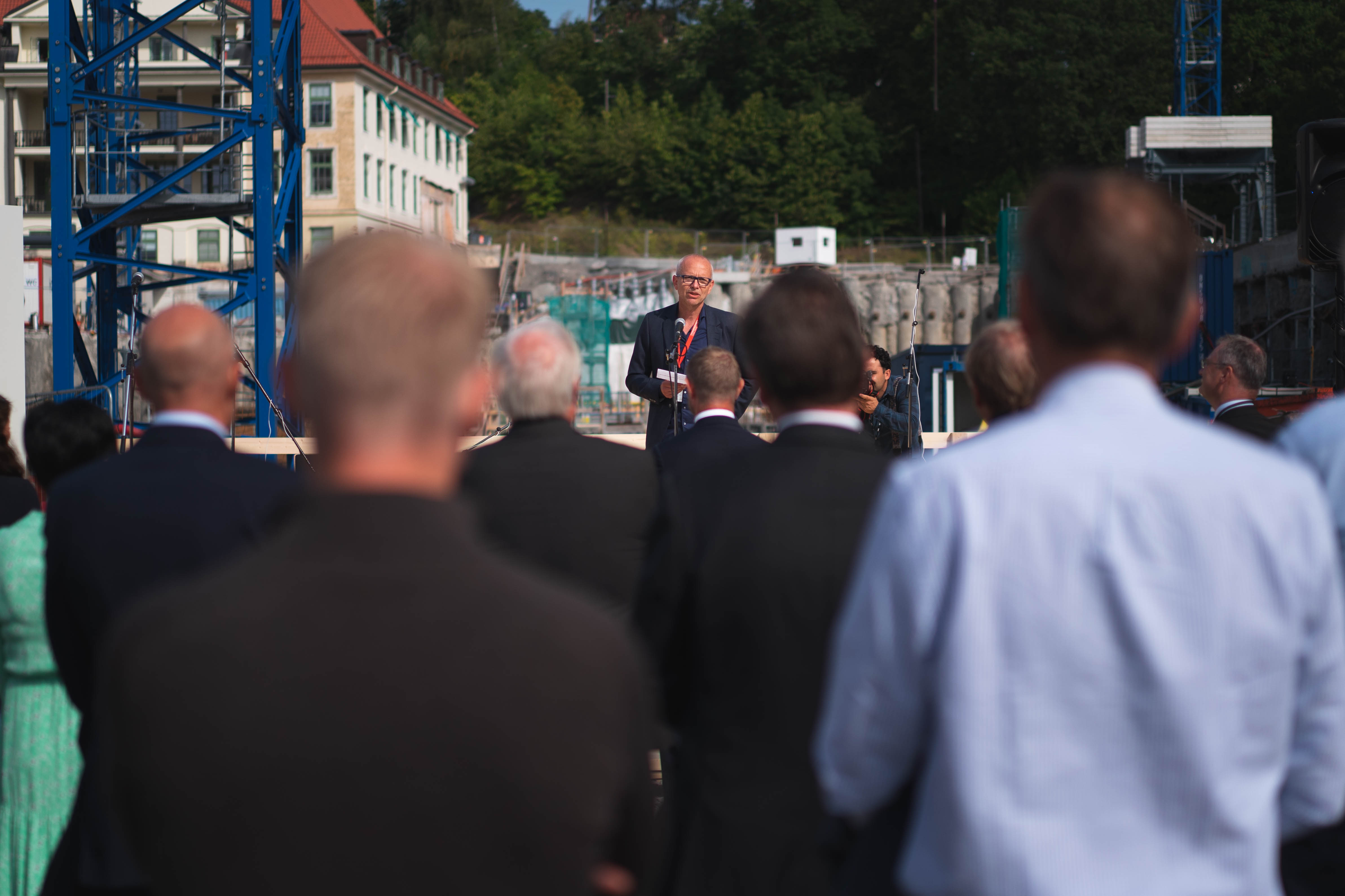 mann holder tale mens publikum hører på