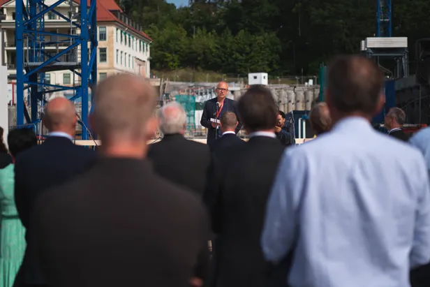 mann holder tale mens publikum hører på