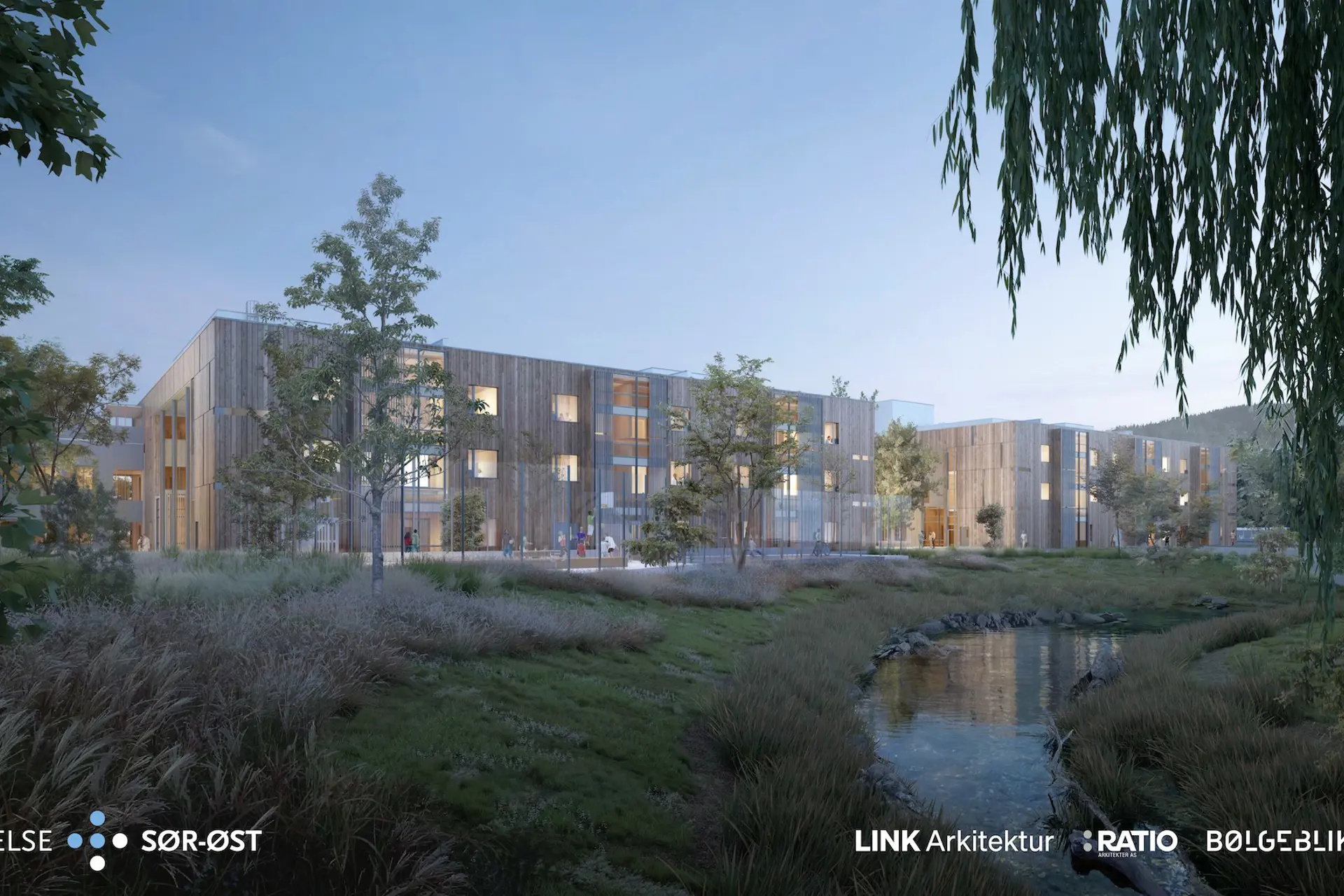 Perspektiv mot psykiatribyggene i tre med hage og en elv i forkant