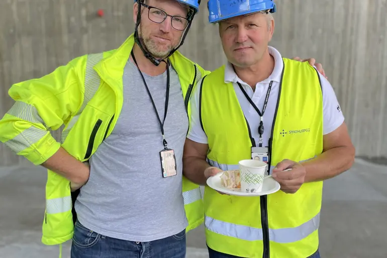Prosjektleder og byggeleder feirer med kake