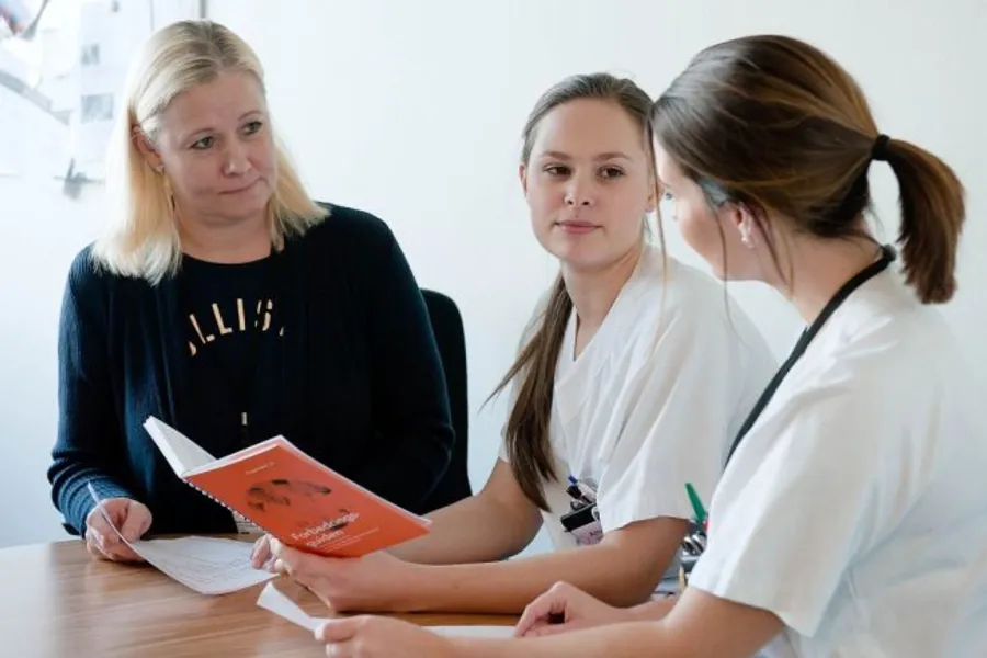 En gruppe kvinner som ser på en bok