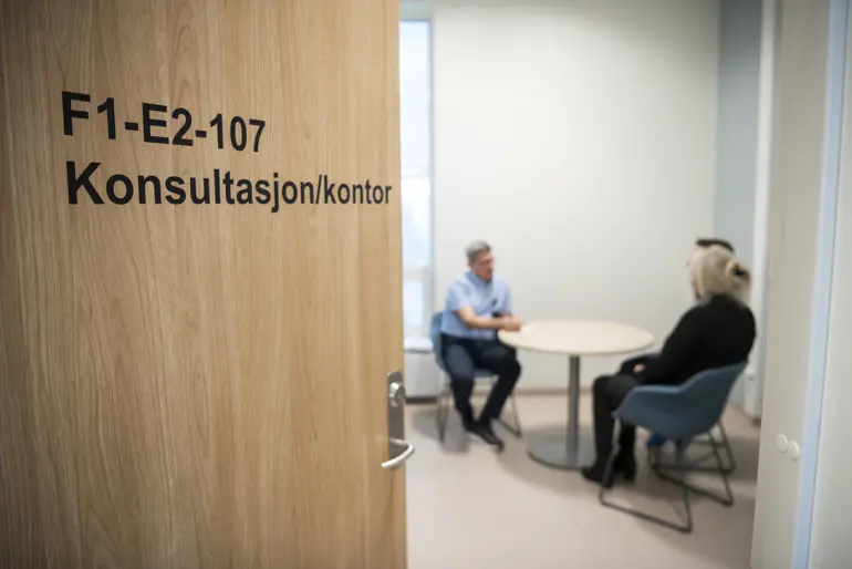 Behandler og pasient i samtale på kontor