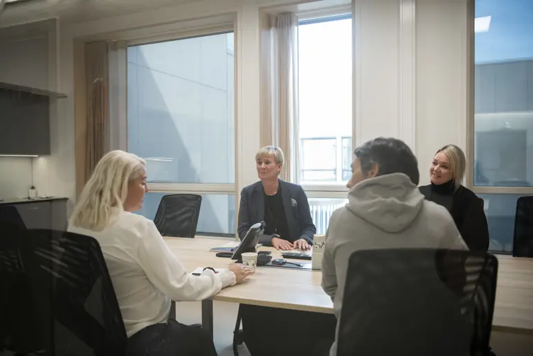 Fire mennesker i et møterom