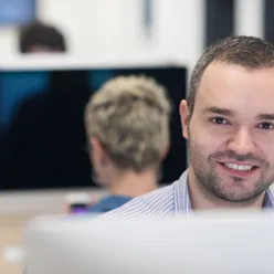 En mann som smiler til kameraet