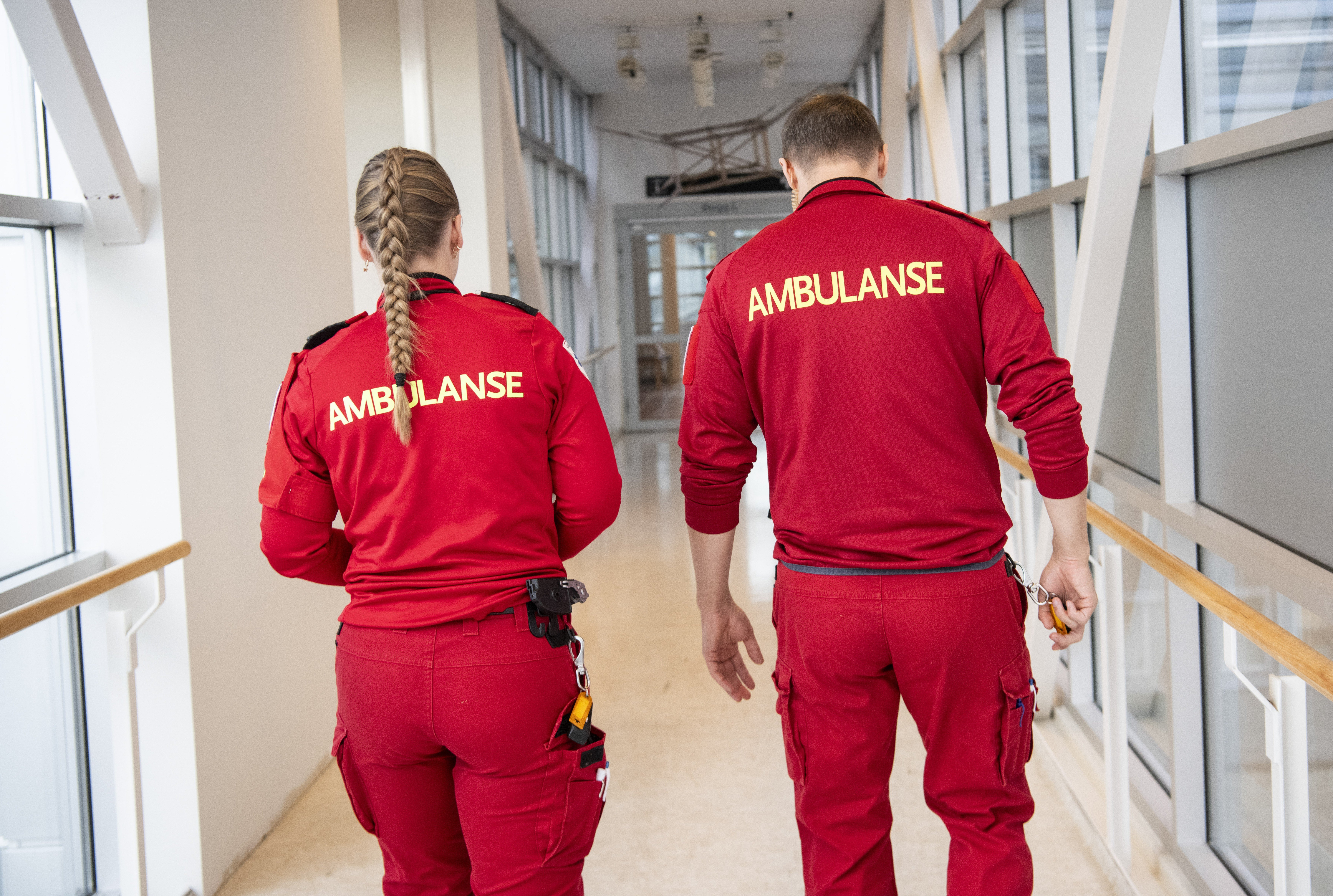 To ambulansearbeidere går sammen i en gang