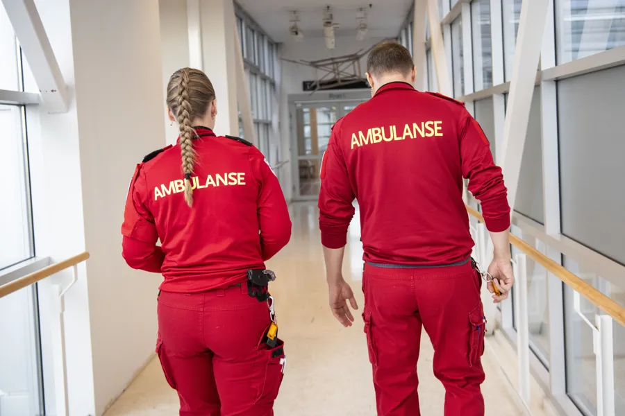 To ambulansearbeidere går sammen i en gang