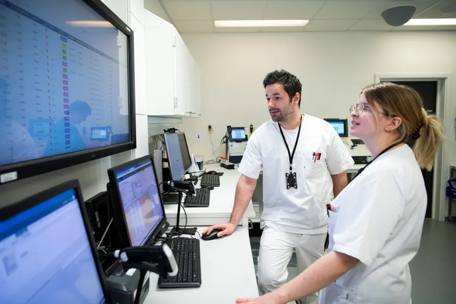 En mann og en kvinne i et rom med datamaskiner