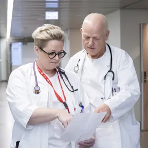 To sykehusansatte studerer et dokument