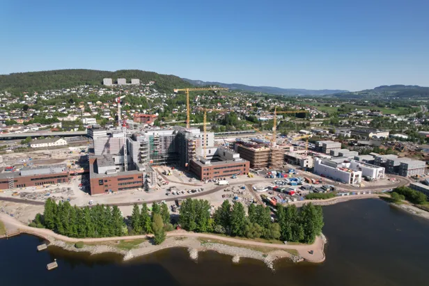 dronebilde av byggeplass med sjø foran