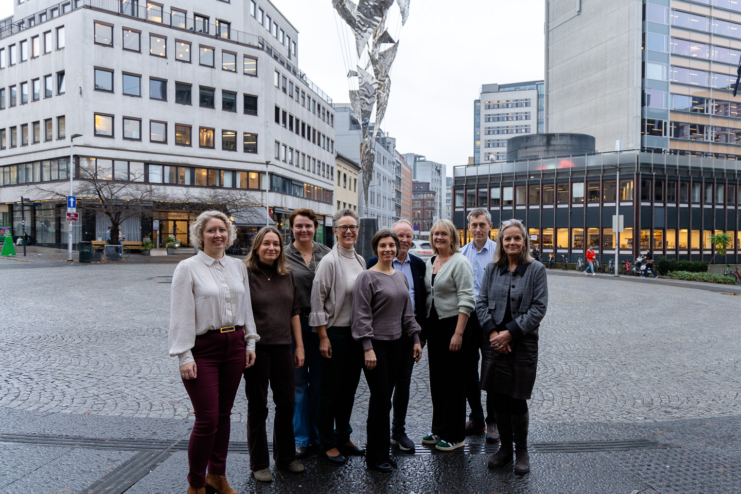 En gruppe mennesker som poserer for et bilde foran en bygning