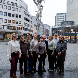 En gruppe mennesker som poserer for et bilde foran en bygning