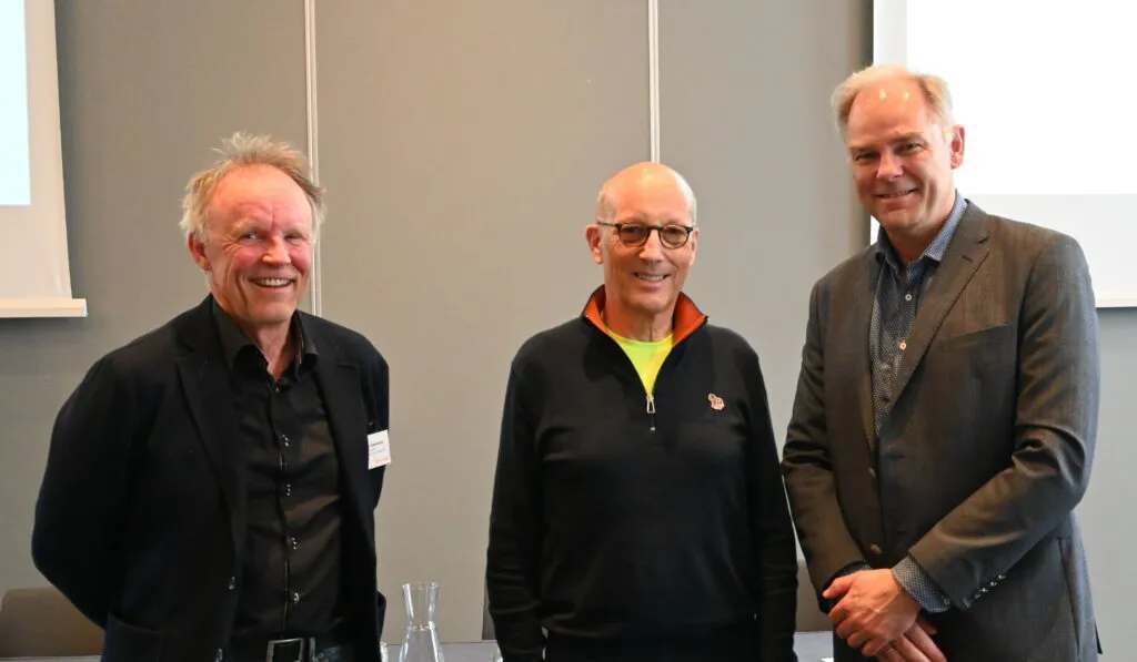 En gruppe mennesker som poserer for et bilde foran en bygning