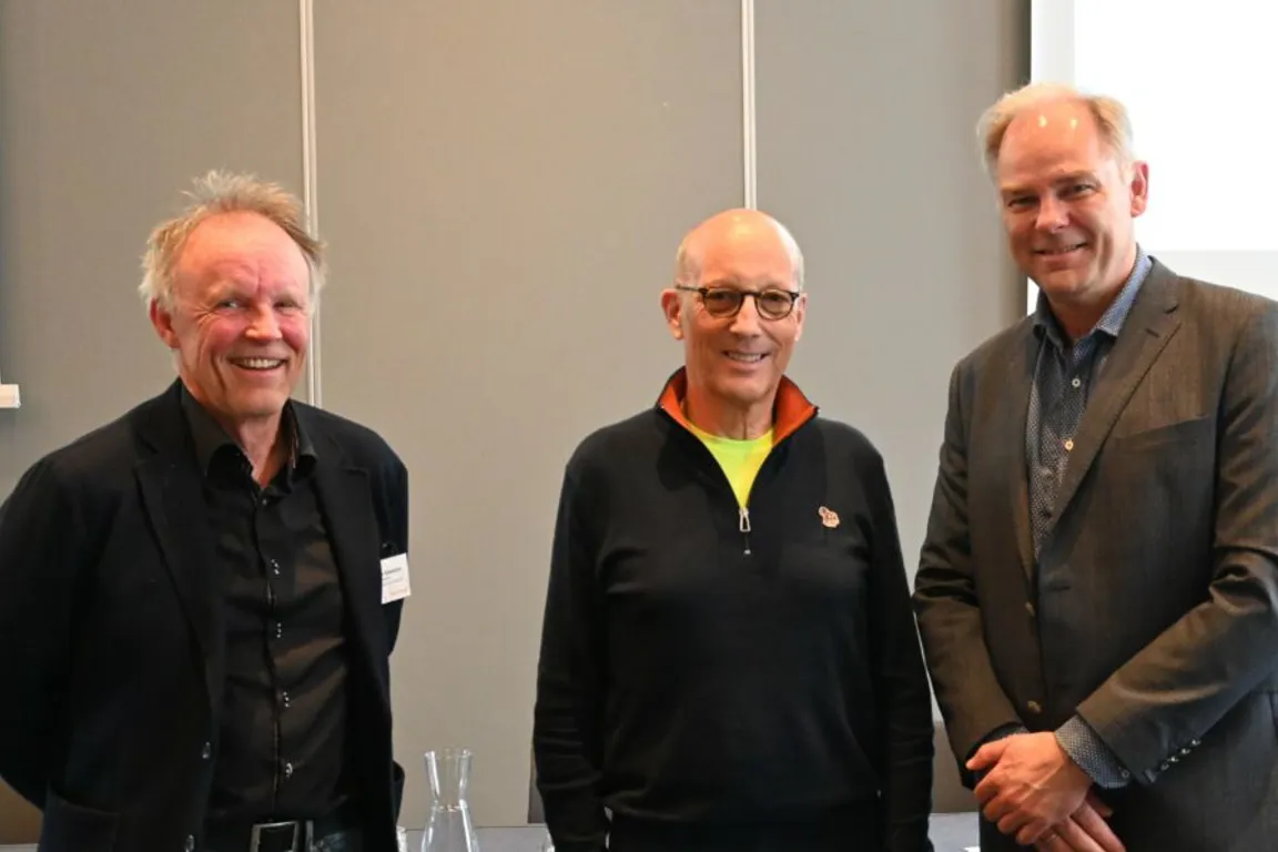 En gruppe mennesker som poserer for et bilde foran en bygning
