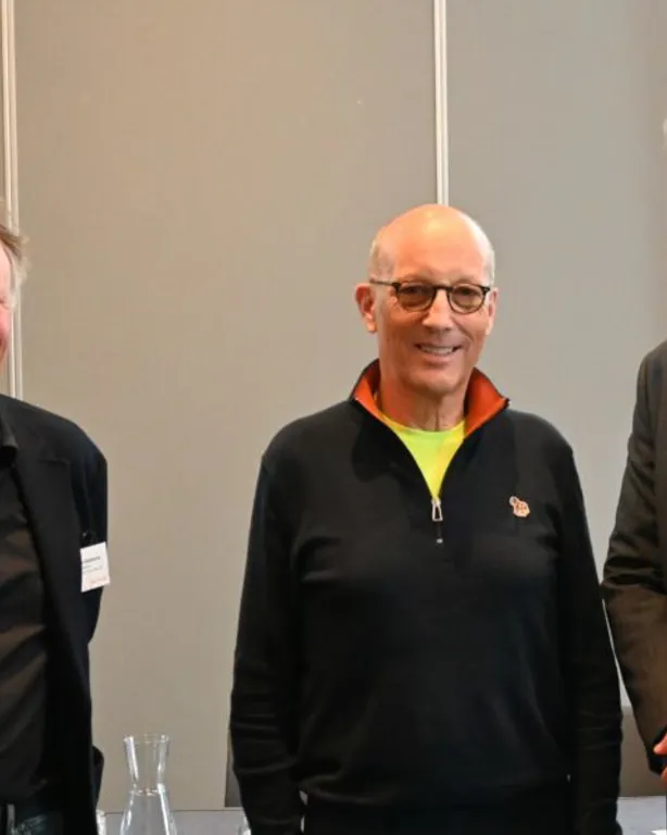 En gruppe mennesker som poserer for et bilde foran en bygning