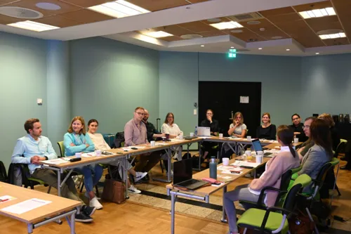En gruppe mennesker som sitter ved bord