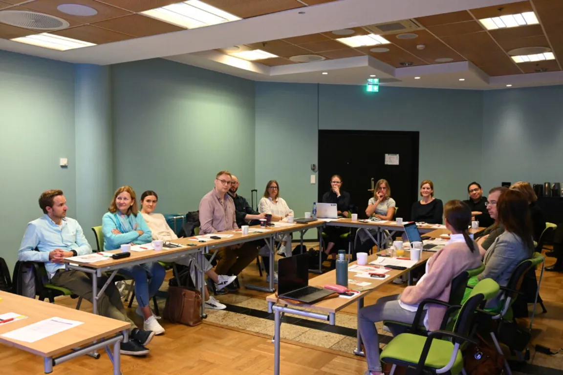 En gruppe mennesker som sitter ved bord