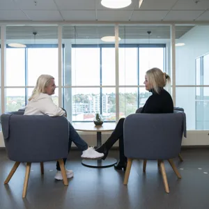 Terapeut og pasient sitter i sofa med ryggen til