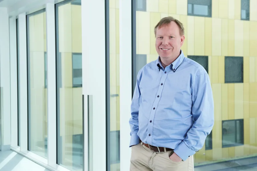 En mann som står foran en glassvegg