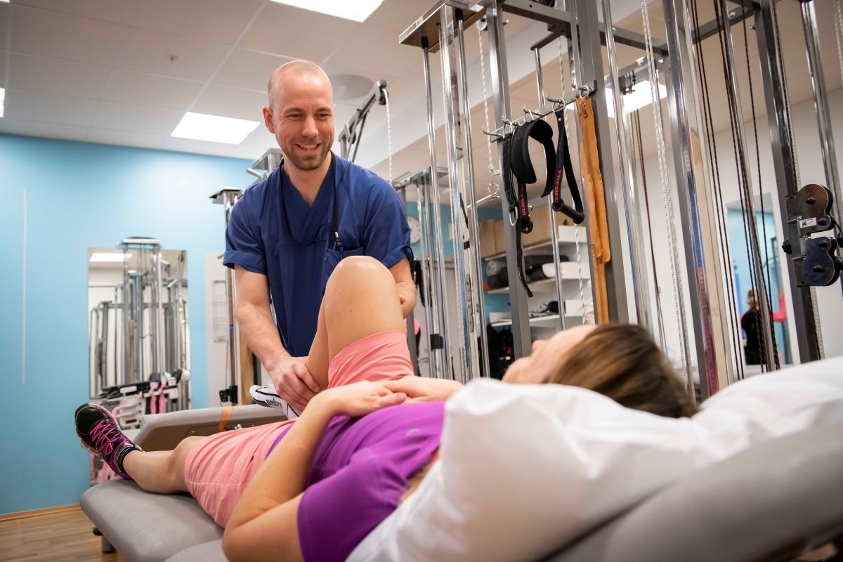 En mann som står over en kvinne i et treningsstudio