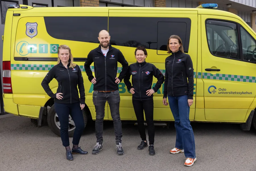 gruppe mennesker foran en ambulanse