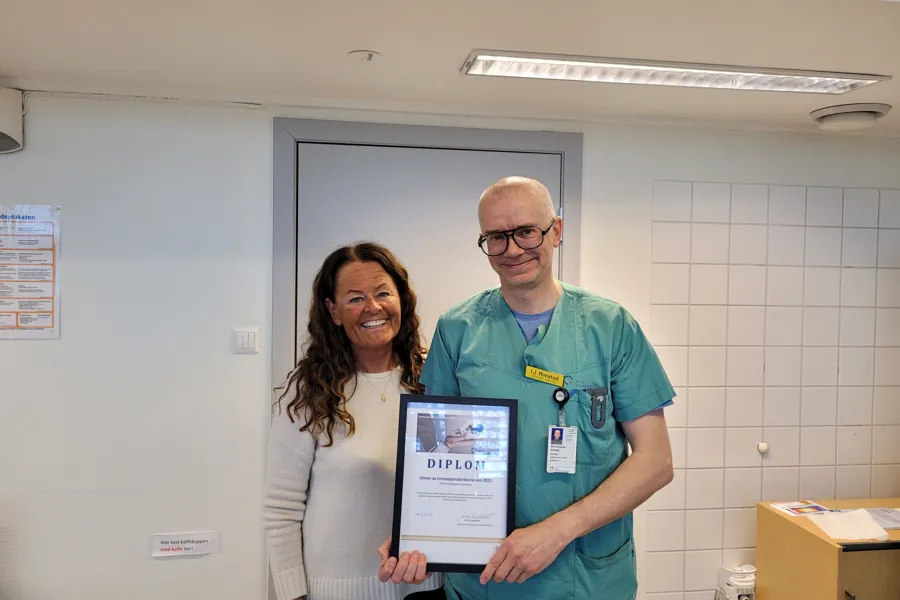 En mann og en kvinne som holder en plakett