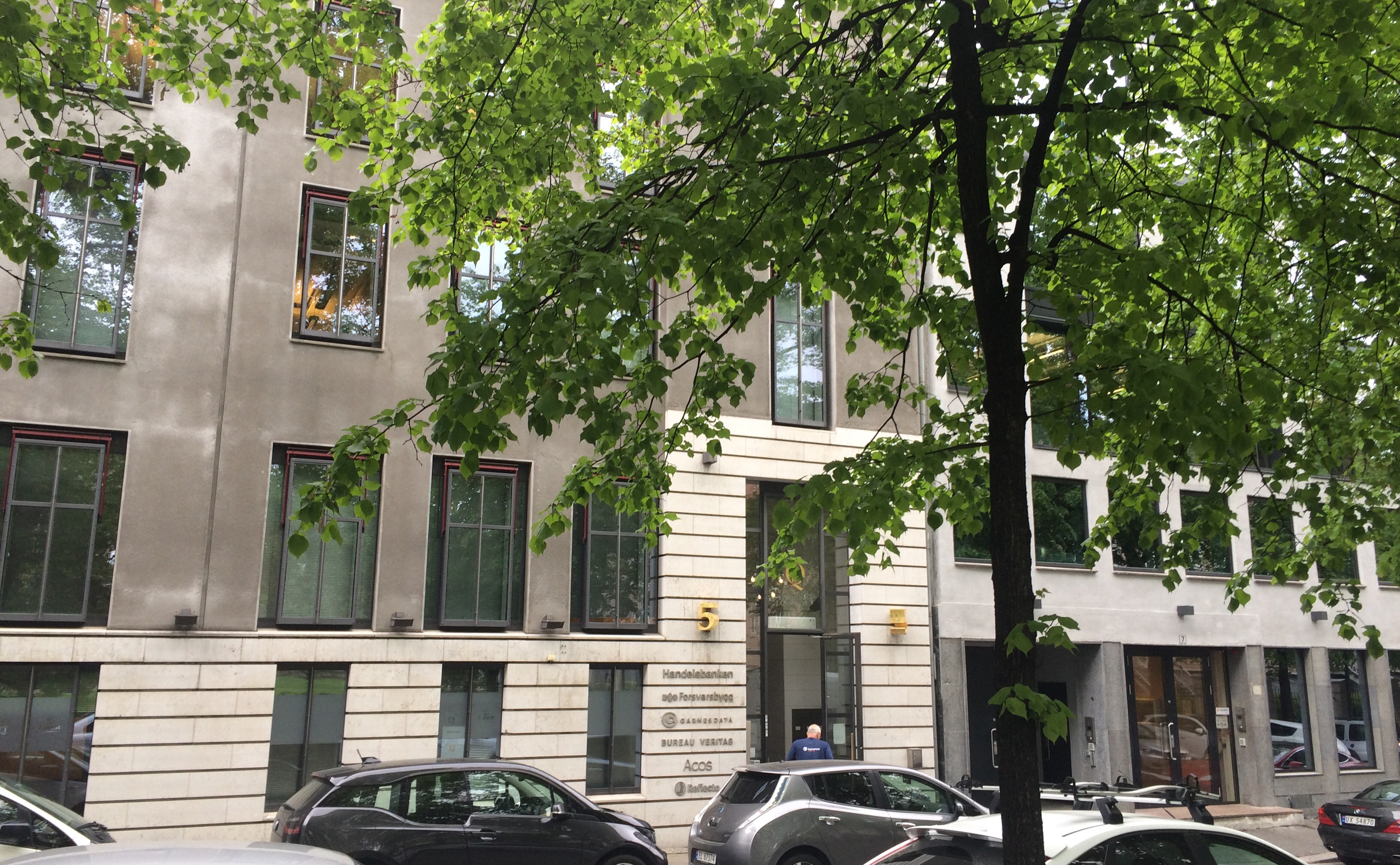 En bygning med biler parkert foran