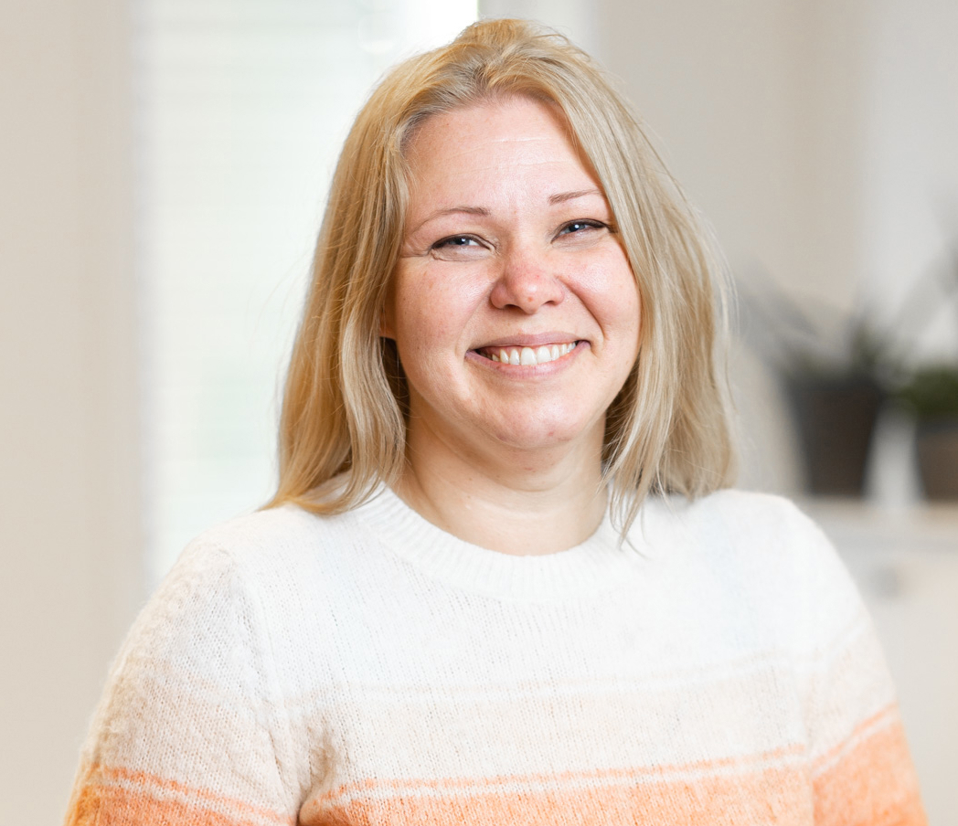 En kvinne som smiler til kameraet