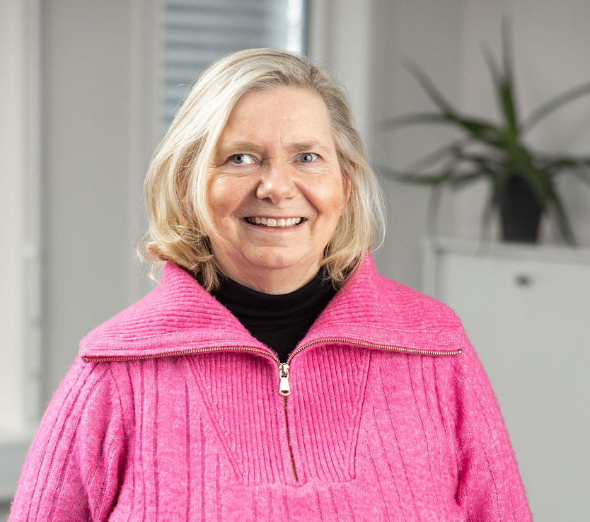 En kvinne som smiler til kameraet