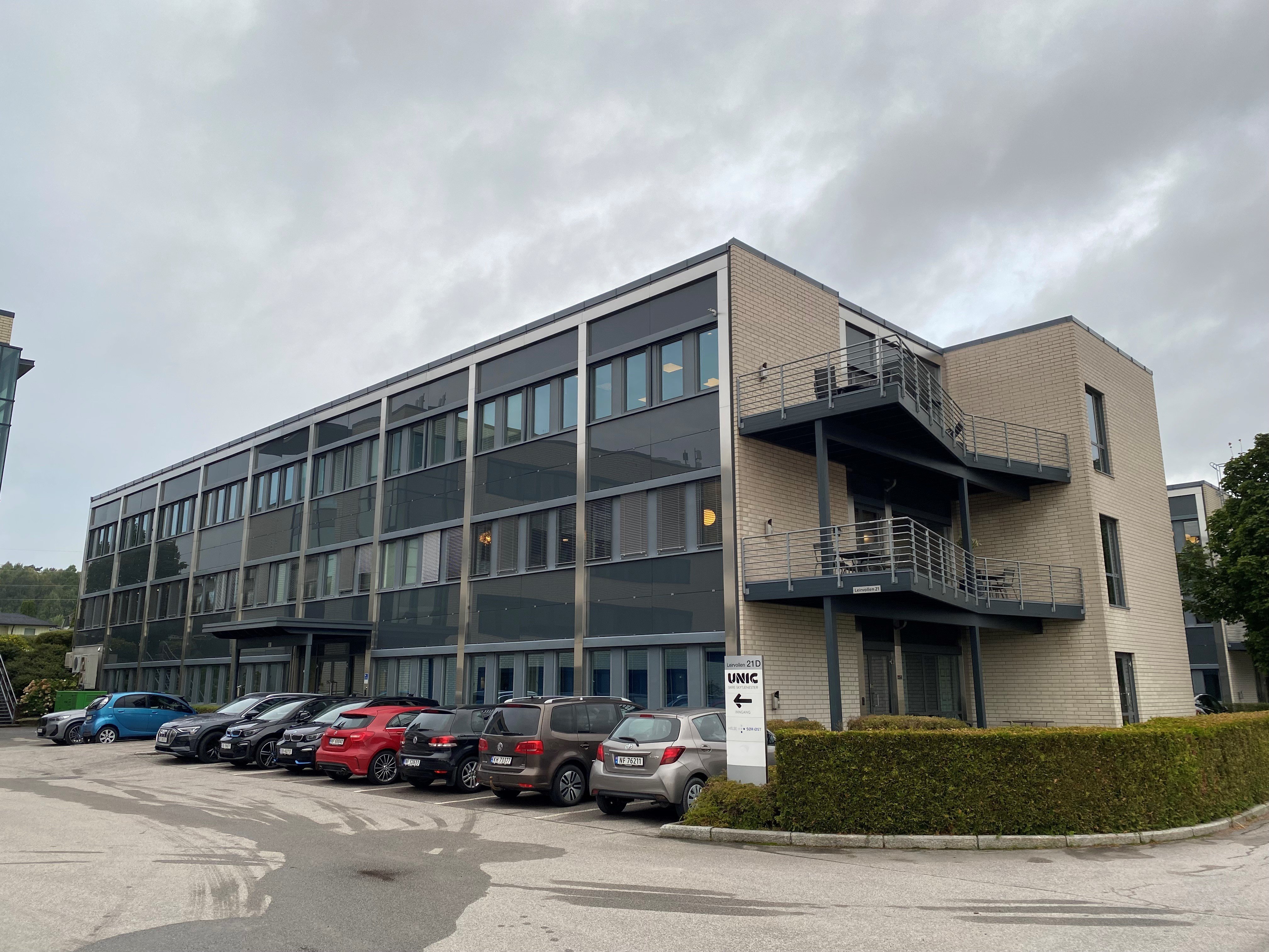 En bygning med biler parkert foran