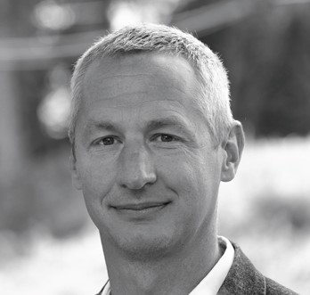 En mann som smiler til kameraet