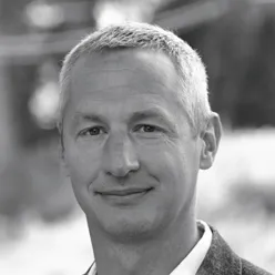 En mann som smiler til kameraet