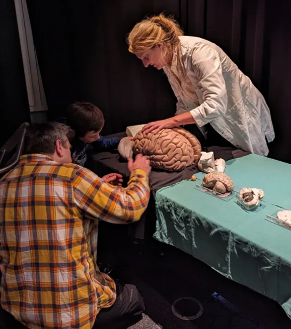 En person og to gutter som spiller et spill