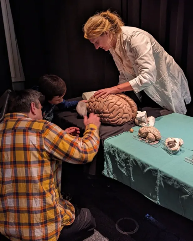 En person og to gutter som spiller et spill