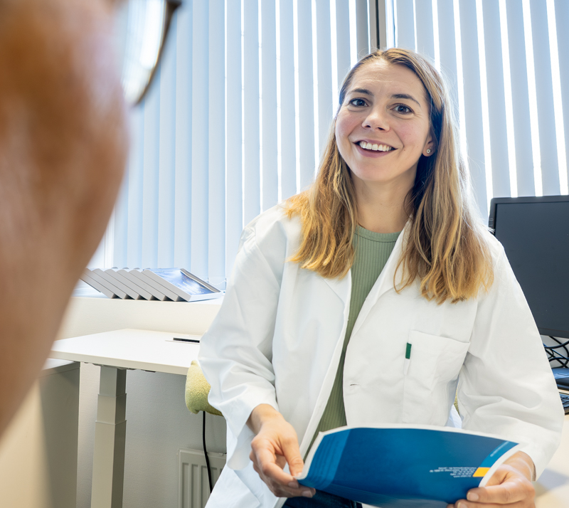 kvinnelig lege snakker med mannlig pasient