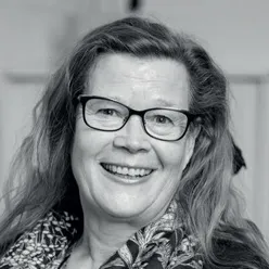 En kvinne med briller som smiler