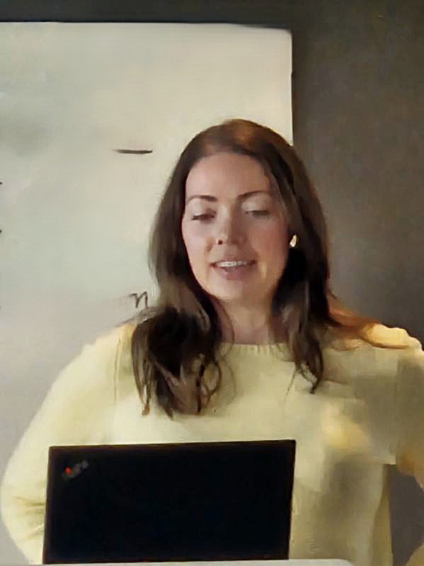 En person som smiler og ser på en bærbar PC