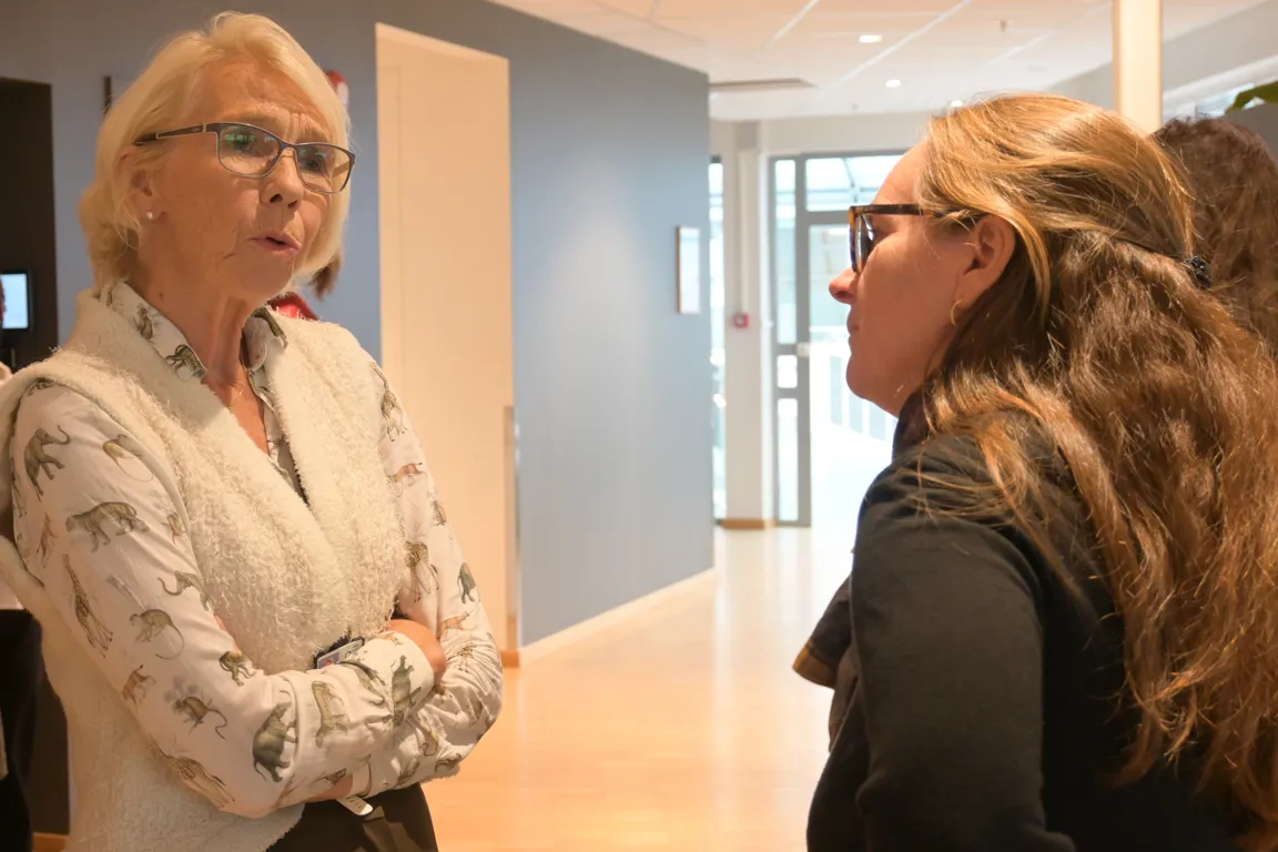 En person som snakker med et par kvinner