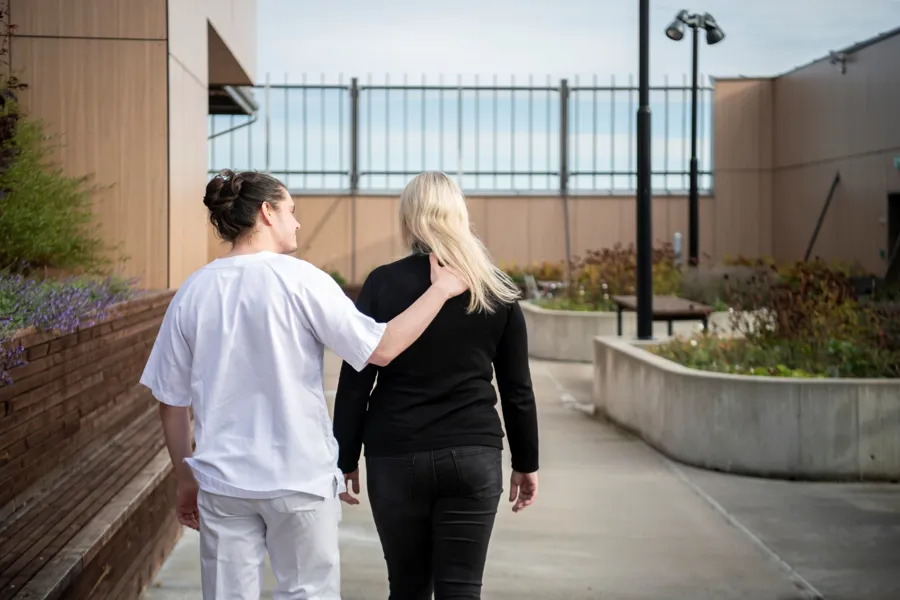 Ansatt og pasient i samtale utendørs